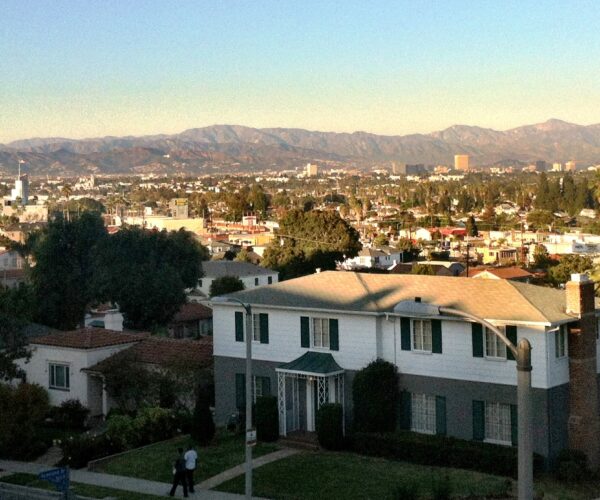 A typical street scene of homes in the View Park neighborhood, with the Baldwin Hills Crenshaw Plaza and the Hollywood Hills seen in the background.