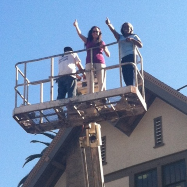 two women and a man on a forklift