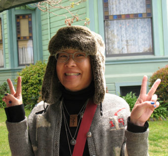 Image of young woman in hat out front of a historic house.