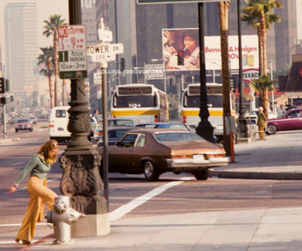 Woman walking on to sidewalk on San Vicente Blvd