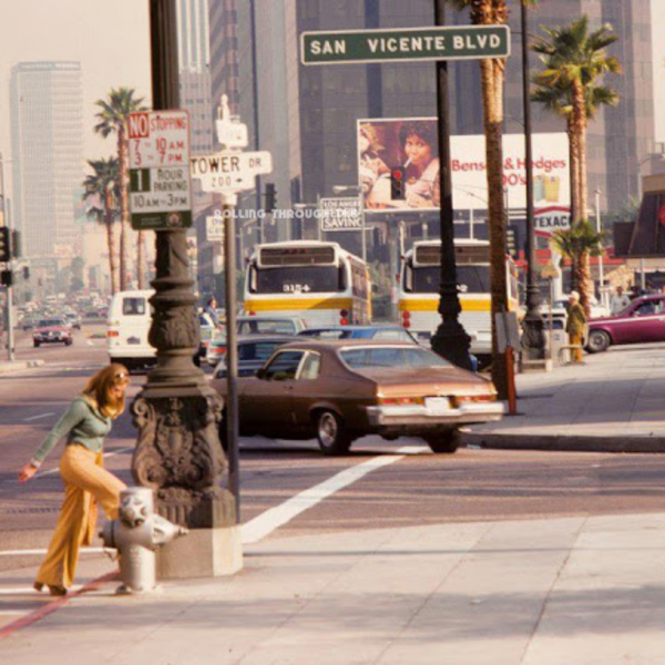 Woman walking on to sidewalk on San Vicente Blvd